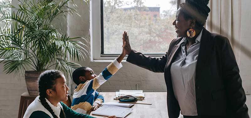 Teacher high fiving students